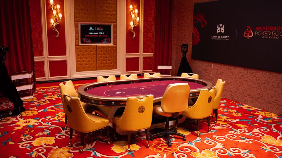 Red Dragon扑克室内的扑克牌桌与座椅,墙上有Red Dragon Poker Room标识